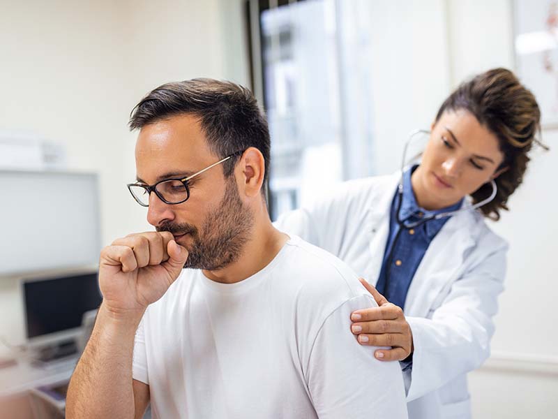 A female doctor at the clinic performs auscultation of the lungs of a patient with symptoms of coronavirus or pneumonia.